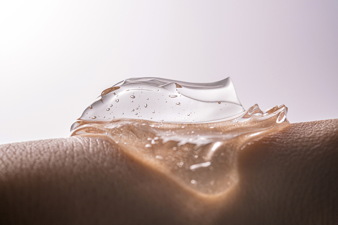 Transparent gel drop with bubbles on a hand photographed close up.